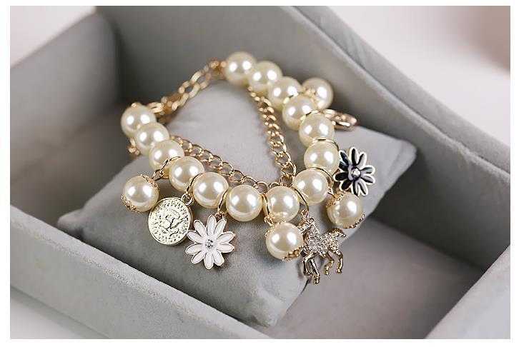 Pearl Flower Bracelet with floral design and charms displayed on a cushion.
