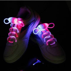 Illuminated LED sport shoe laces glowing on sneakers in the dark.