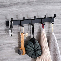 Punch free Bathroom black coat hooks with six hooks for clothes and towels, mounted on a wall with accessories hanging.