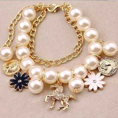 Pearl Flower Bracelet with floral design and pearl beads on a gold chain.
