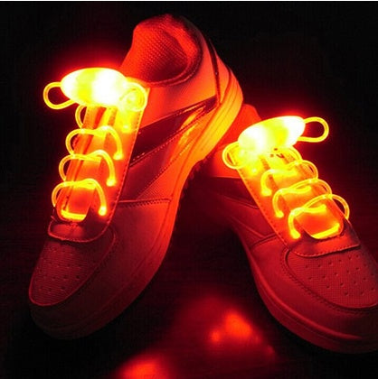 LED sport shoe laces glowing on sneakers with bright red light.