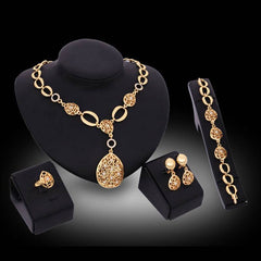 Four piece jewelry set with necklace, earrings, bracelet, and ring in gold alloy, featuring bamboo link chain style.