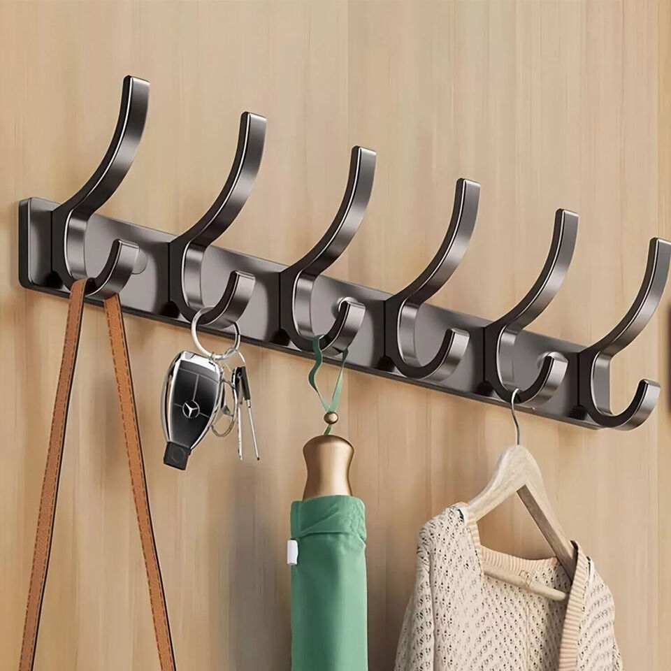 Over door hanger with aluminum hooks holding clothes and items on a wall-mounted rack.