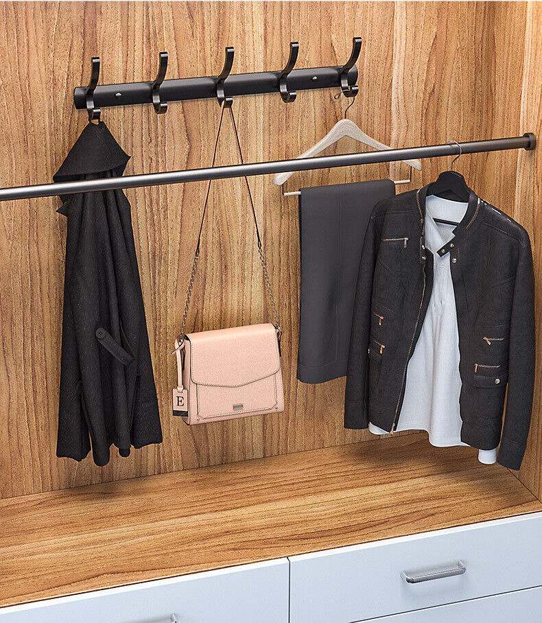 Over door hanger with multiple hooks holding a coat, jacket, and bag in a wooden closet.