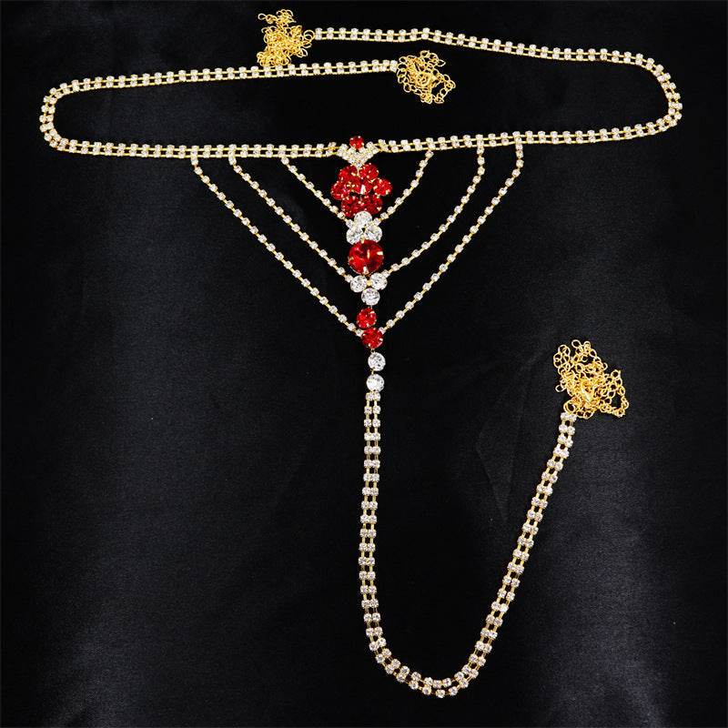 Heart rhinestone panty body jewelry with gold and red rhinestones on black background.